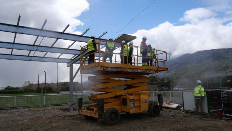 Photo de la pose du premier panneau des ombrières photovoltaïques sur le parking du stade de Chauvilly à Gex le 16 avril 2024.