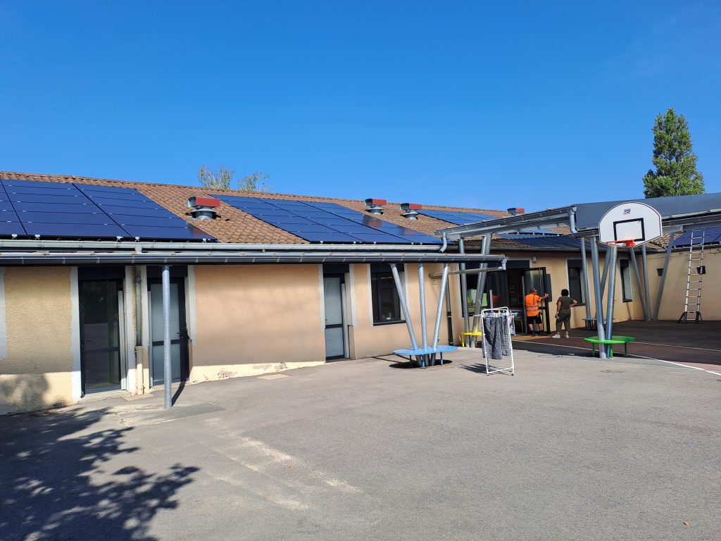 Installation d'une centrale photovoltaïque sur la toiture de l'école primaire de Saint-Marcel-en-Dombes, composée de 237 panneaux produisant l'équivalent de la consommation annuelle de 23 foyers.