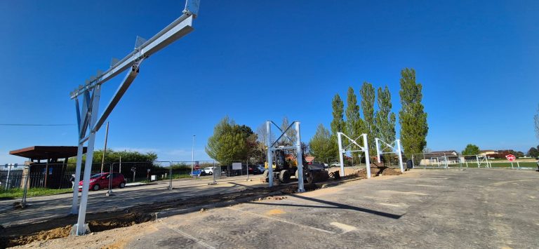 Avancement des travaux d'installation d'une ombrière sur le parking de la halte ferroviaire de St-Marcel-en-Dombes : réalisation des fondations et réseaux, montage des structures en cours